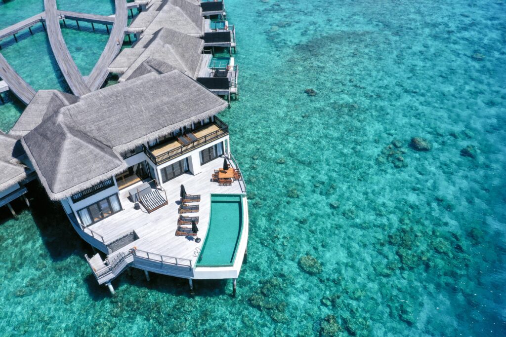 Stunning aerial view of luxury overwater villas in a tropical resort with turquoise waters.