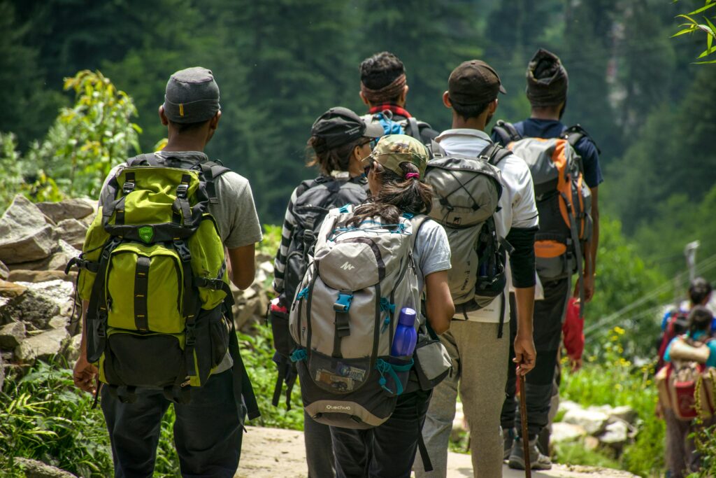 group of hikers trekking through the lush green landscapes of St. Barts. With backpacks and walking sticks, they navigate a scenic trail surrounded by tropical vegetation, embracing the island’s adventurous side beyond its famous beaches.